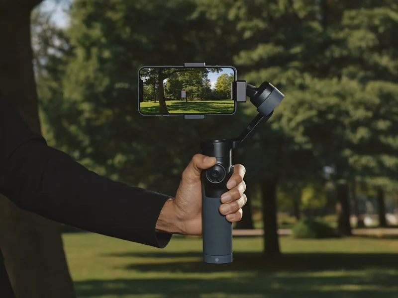 Dreiachsiger Gimbal mit Smartphone, im Gehen von einer Hand gehalten